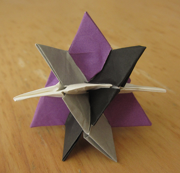 Four intersecting triangles, in the colors purple, white, gray, black