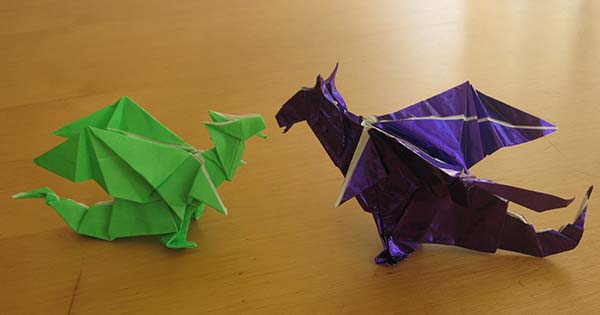 two dragons, one smaller green one and larger purple one, looking at each other