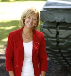 Jeanne Ives standing next to a tank