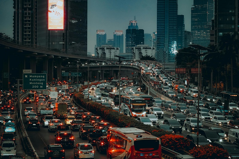 A cityscape at night, with highways densely clogged with traffic