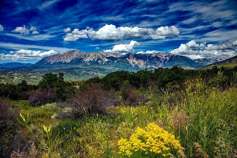 A majestic mountain range, with woodlands in the foreground