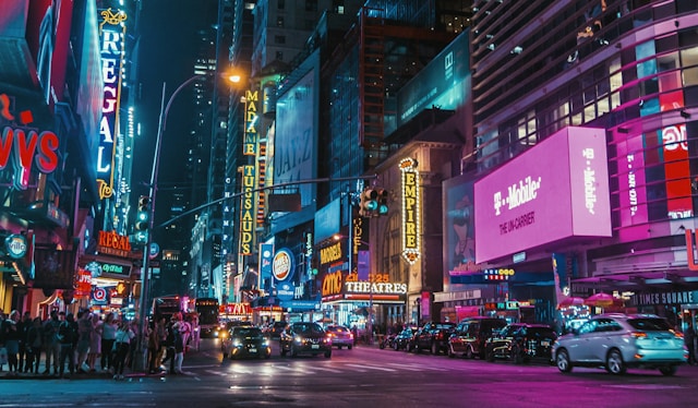 A bustling city intersection at night, blanketed with neon signs and billboards