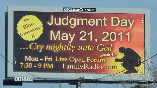 A red and yellow billboard reading: "Judgment Day May 21, 2011 - Cry mightily unto God" with a silhouette of a man praying