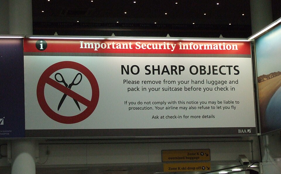 Airport security sign reading "No Sharp Objects"