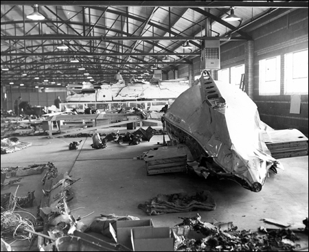 The wreckage of a bomb-destroyed plane in a hangar