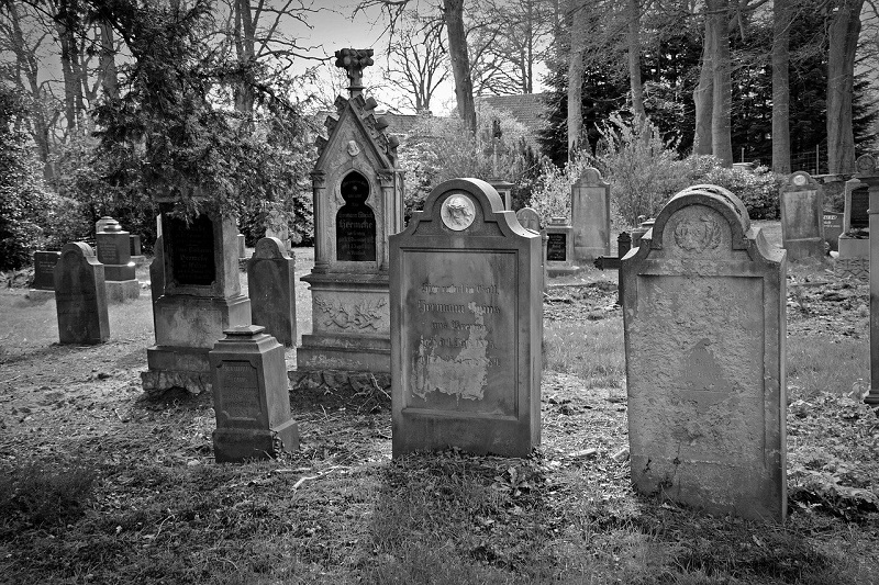A black-and-white photograph of old tombstones