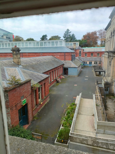 A photo of an outdoor area with low brick buildings and a driveway.