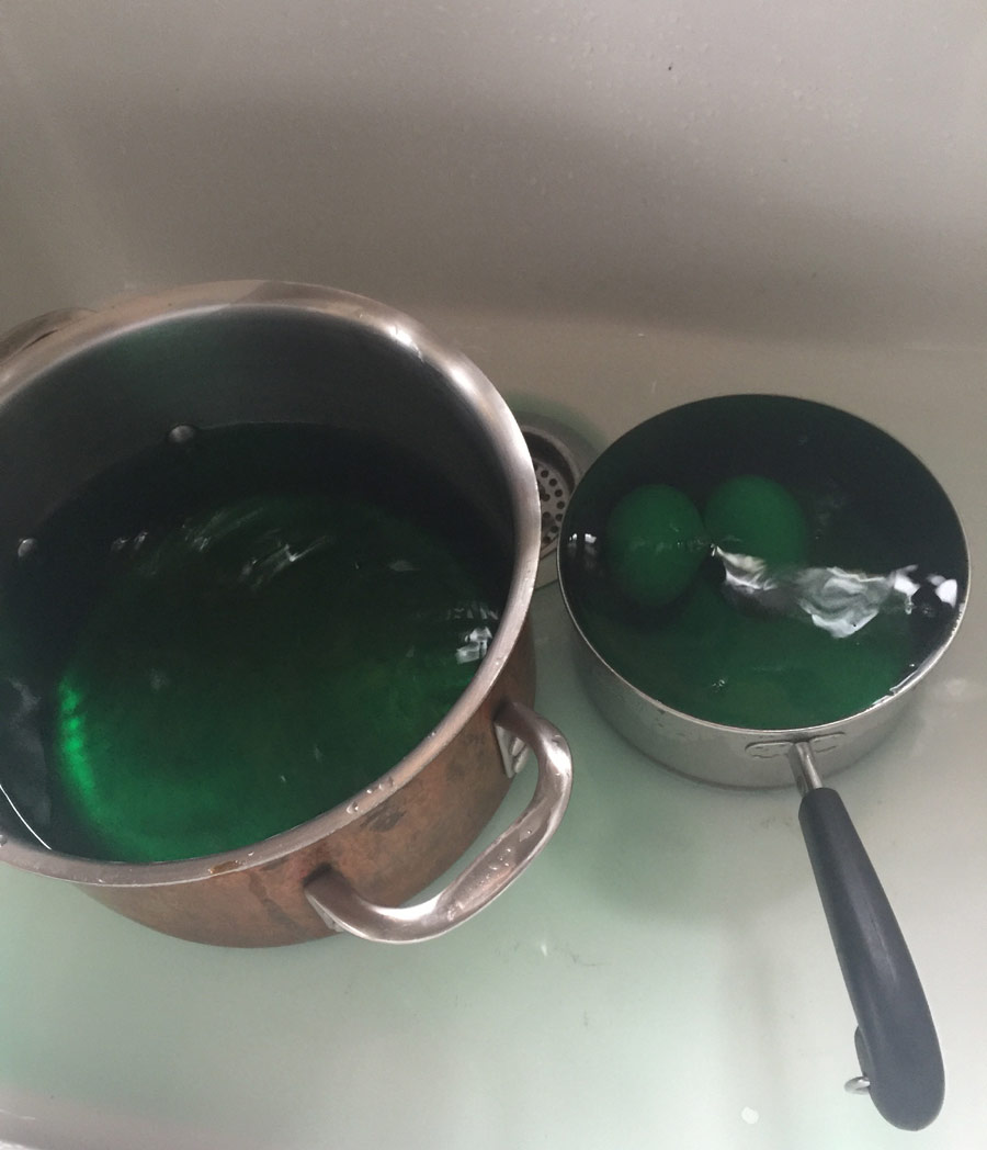 eggs in pan with green dye, cooling